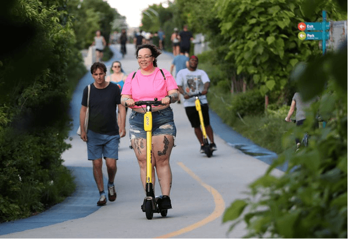 People ride electric scooters along The 606 recreational trail in Chicago. (Brian Cassella / Chicago Tribune)